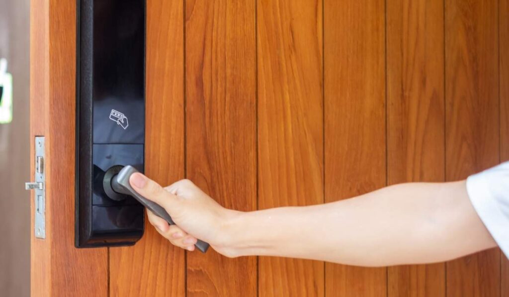 Una persona abre una puerta utilizando.
