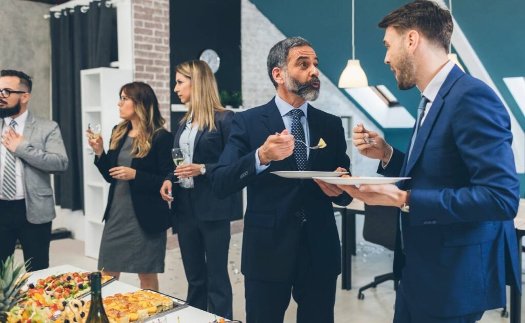 A group of business professionals networking at a corporate event, engaged in conversation and exchanging ideas