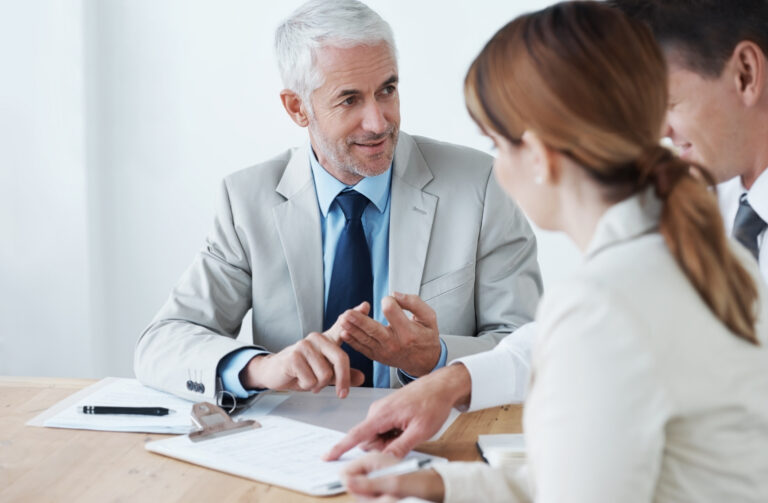 Un hombre y una mujer conversan animadamente en una mesa.