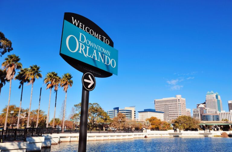 Señal de "Downtown Orlando" frente a palmeras, destacando el ambiente tropical de la ciudad.