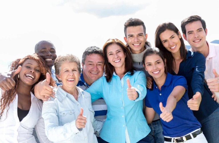 Un grupo de personas sonrientes levantando el pulgar en señal de aprobación.