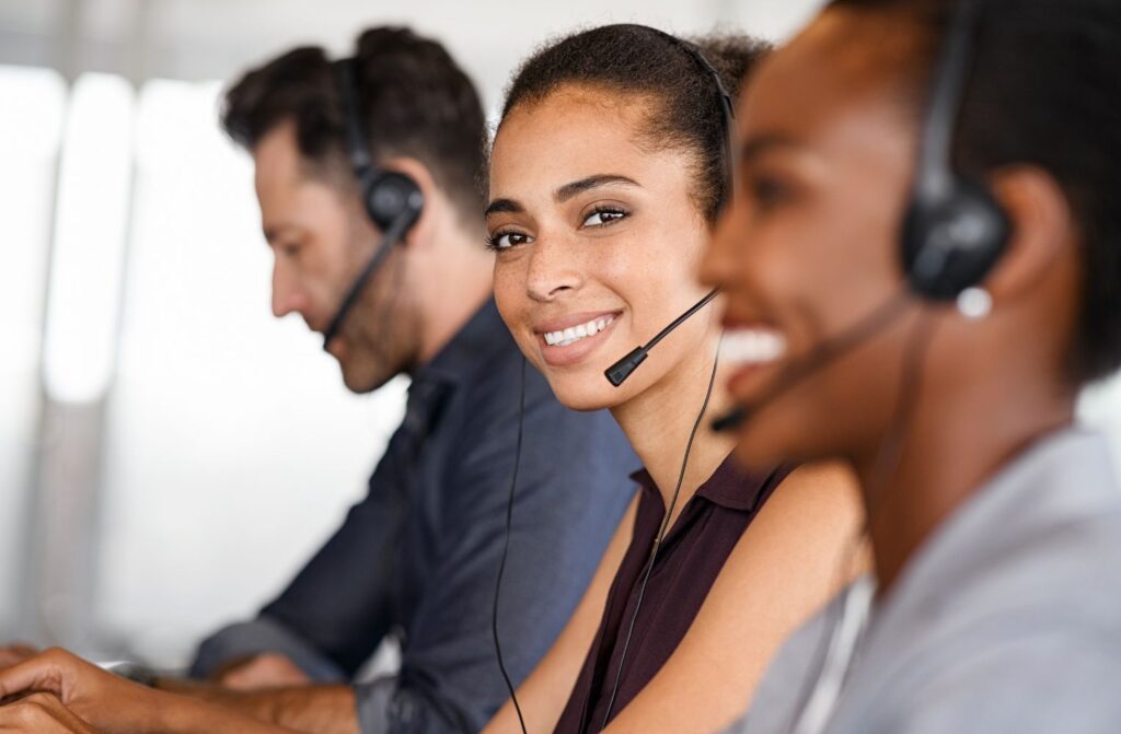 Mujer feliz usando un auricular en un call center, Home Vacation Group transmitiendo una actitud positiva y servicial.