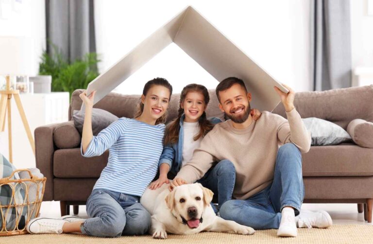 Invertir en casas vacacionales con Una familia sentada en el suelo con un perro debajo de la casa, disfrutando de un momento juntos.