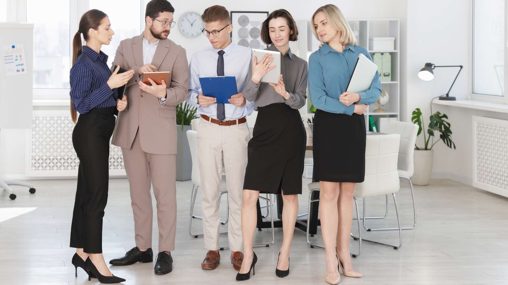 Five business people standing together in an office, representing the Home Vacation Group team