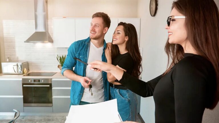 Una pareja en la cocina, el hombre sostiene un papel mientras conversan sobre los beneficios de un property manager en Orlando.