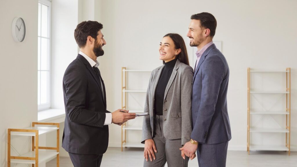 Tres profesionales conversan en una oficina sobre autogestión y gestión profesional.