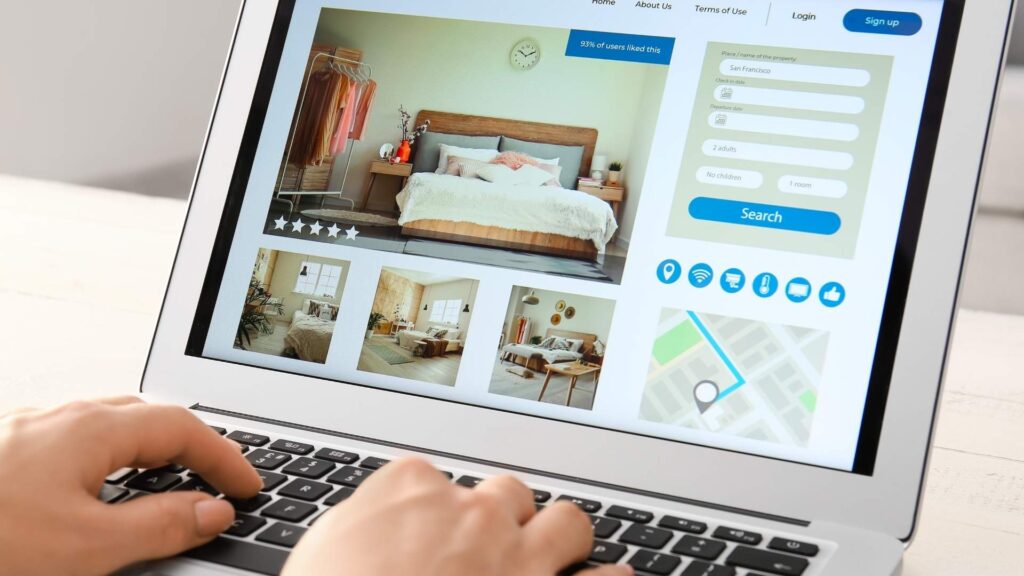 Persona usando una laptop para explorar opciones de alojamiento más allá de Airbnb.