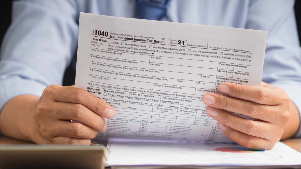 Hombre sosteniendo un formulario de impuestos, simbolizando la transparencia financiera.
