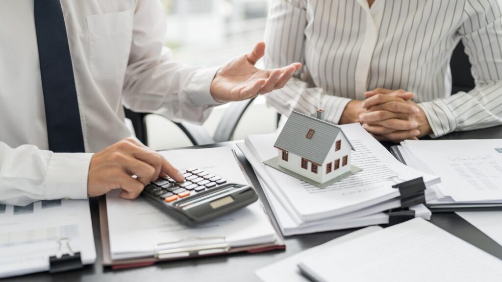 Un agente inmobiliario y un cliente discuten la compra de una casa vacacional.
