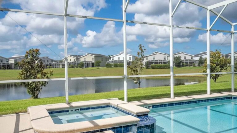 Piscina y spa con mosquitero frente al lago en una propiedad de lujo en Florida.