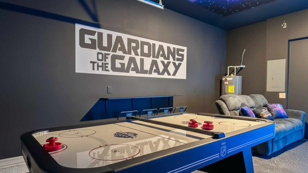 Sala de juegos temática de "Guardianes de la Galaxia" en una casa vacacional con mesa de hockey de aire y zona de descanso.