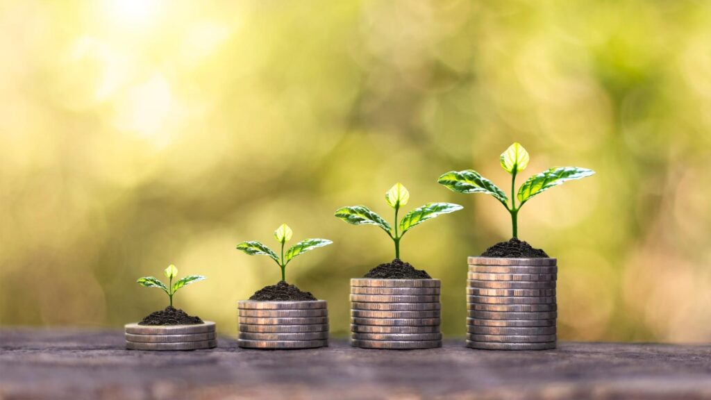 Concepto de crecimiento financiero con plantas brotando de pilas de monedas de plata,