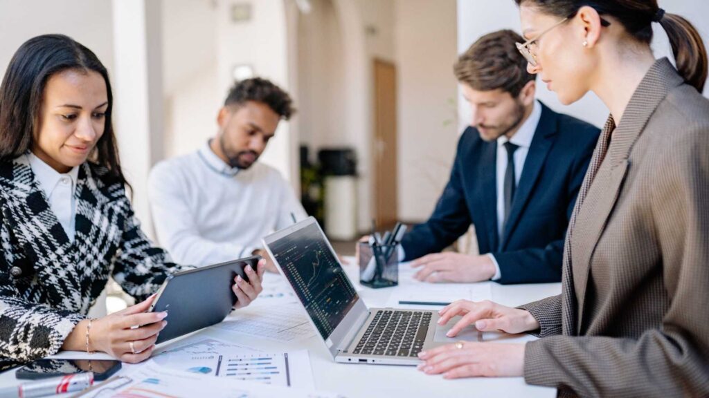Reunión de trabajo corporativa con herramientas digitales para la gestión de ingresos y estrategia inmobiliaria.