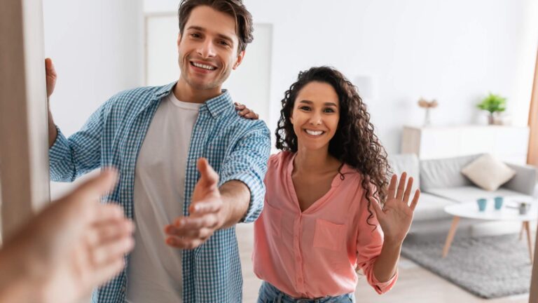 Anfitriones sonrientes dando la bienvenida a huéspedes en una casa vacacional en Orlando.