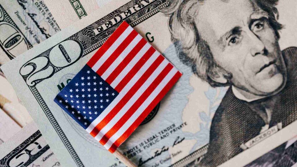 Billetes de dólar con bandera de Estados Unidos que representan beneficios fiscales en real estate para inversores extranjeros.