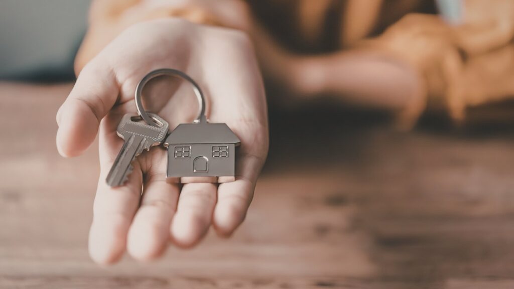 Llaves de casa en mano representando una estrategia de salida para inversores en el mercado inmobiliario.