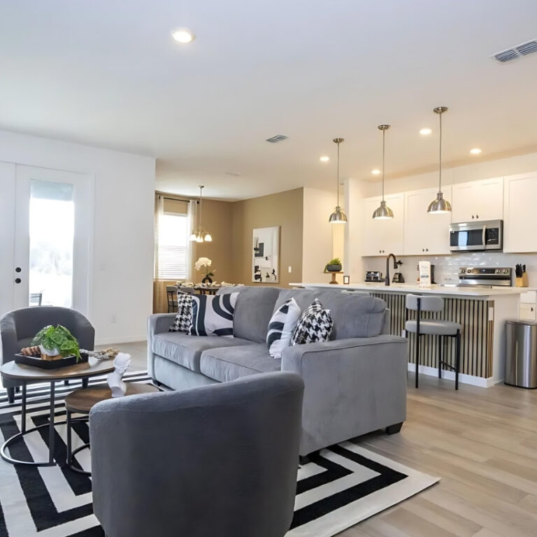 Espacio abierto con sala y cocina moderna diseñado con interiorismo estratégico para propiedades de inversión.