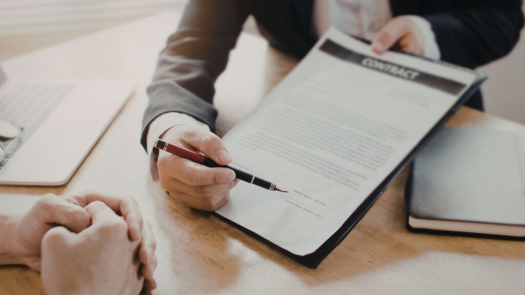 Firma de contrato durante asesoría profesional sobre tendencias inmobiliarias y decisiones de inversión en el mercado.