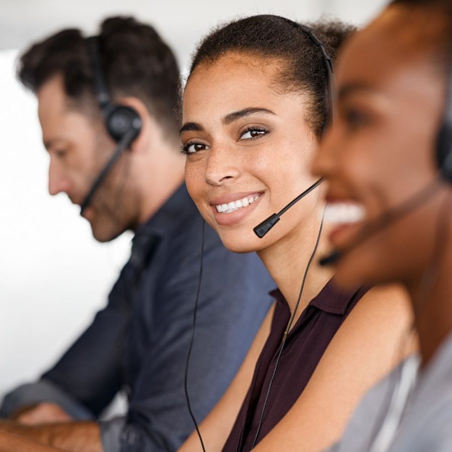 Mujer feliz usando un auricular en un call center, Home Vacation Group transmitiendo una actitud positiva y servicial.