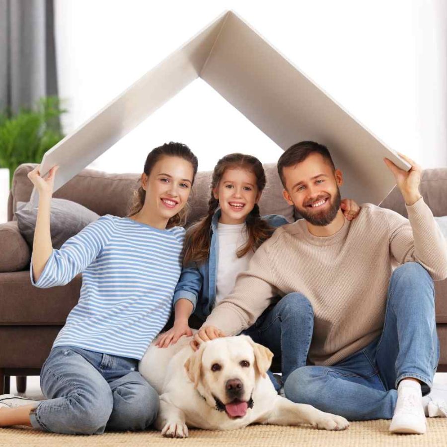 Invertir en casas vacacionales con Una familia sentada en el suelo con un perro debajo de la casa, disfrutando de un momento juntos.