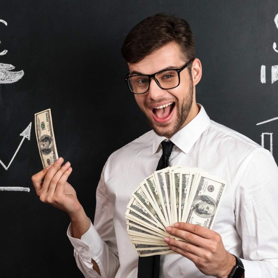 Hombre con gafas sosteniendo dinero y un signo de dólar, ilustrando cómo maximizar ingresos con Home Vacation Group en 2025