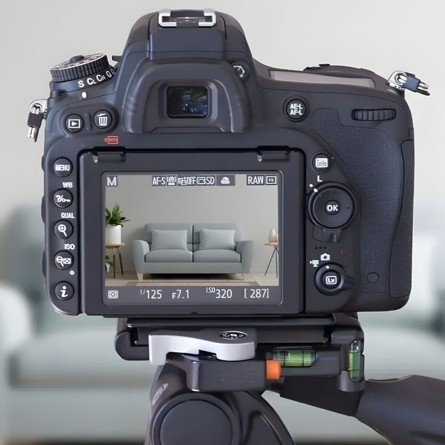 Una cámara sobre un trípode frente a un sofá, lista para capturar momentos especiales
