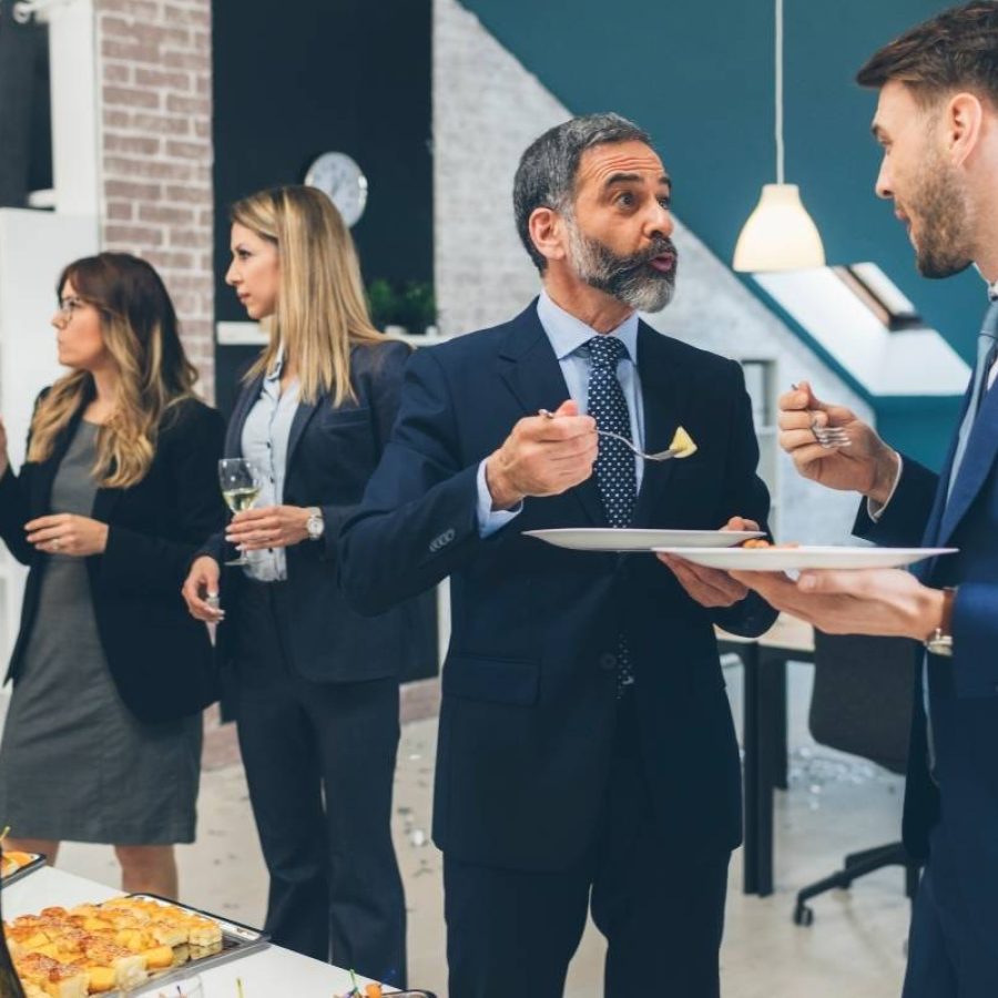 A group of business professionals networking at a corporate event, engaged in conversation and exchanging ideas