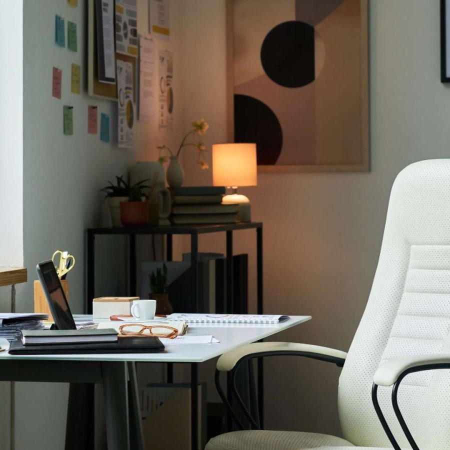 Una silla de oficina blanca se encuentra frente a un escritorio en un entorno de trabajo para nómadas digitales.