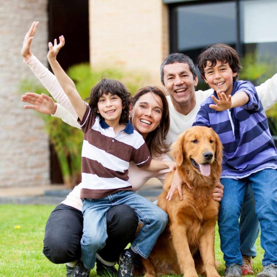 Una familia sonriente posa para una foto con su perro durante unas vacaciones familiares.