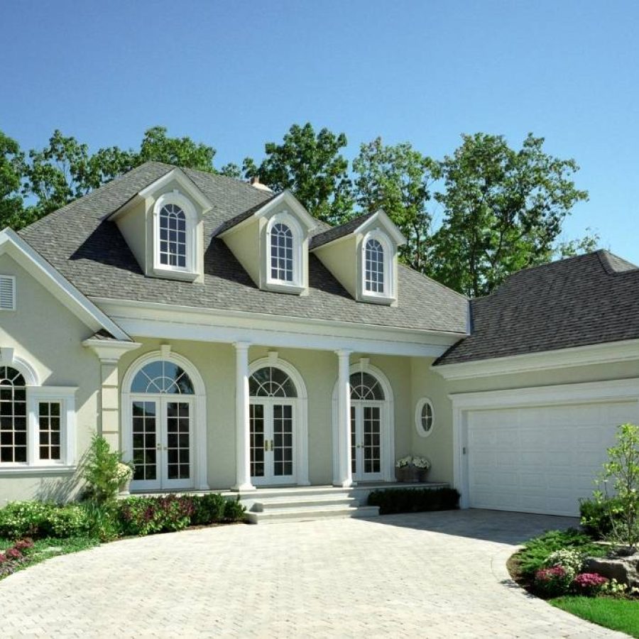 A charming home featuring a spacious driveway and large garage, perfect for a vacation getaway in Orlando