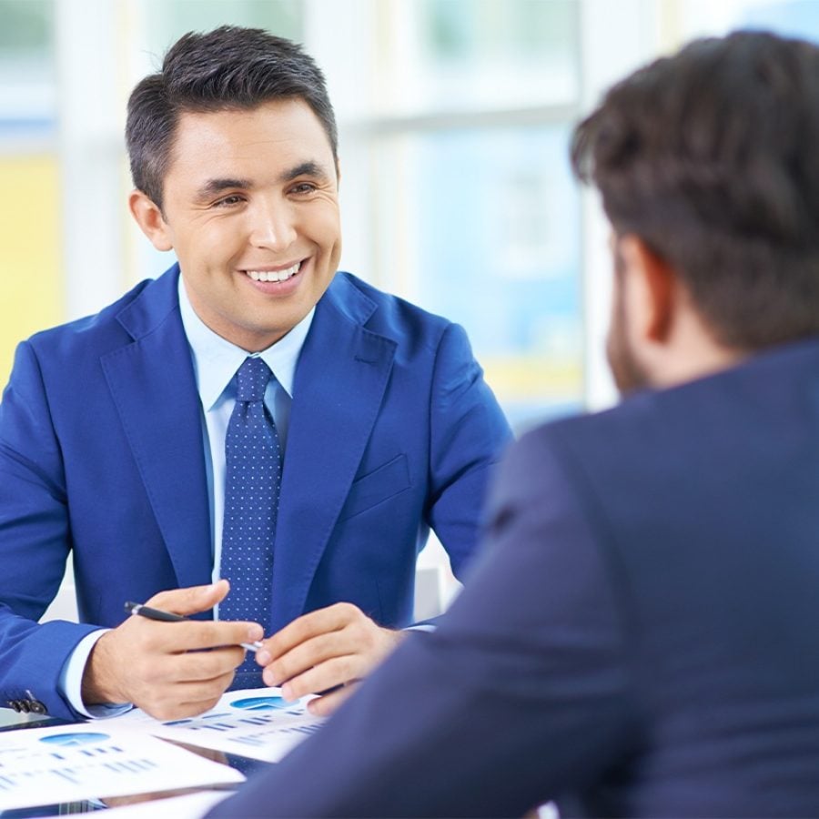 Asesor financiero explicando impuestos sobre propiedades en Estados Unidos a inversionista extranjero.