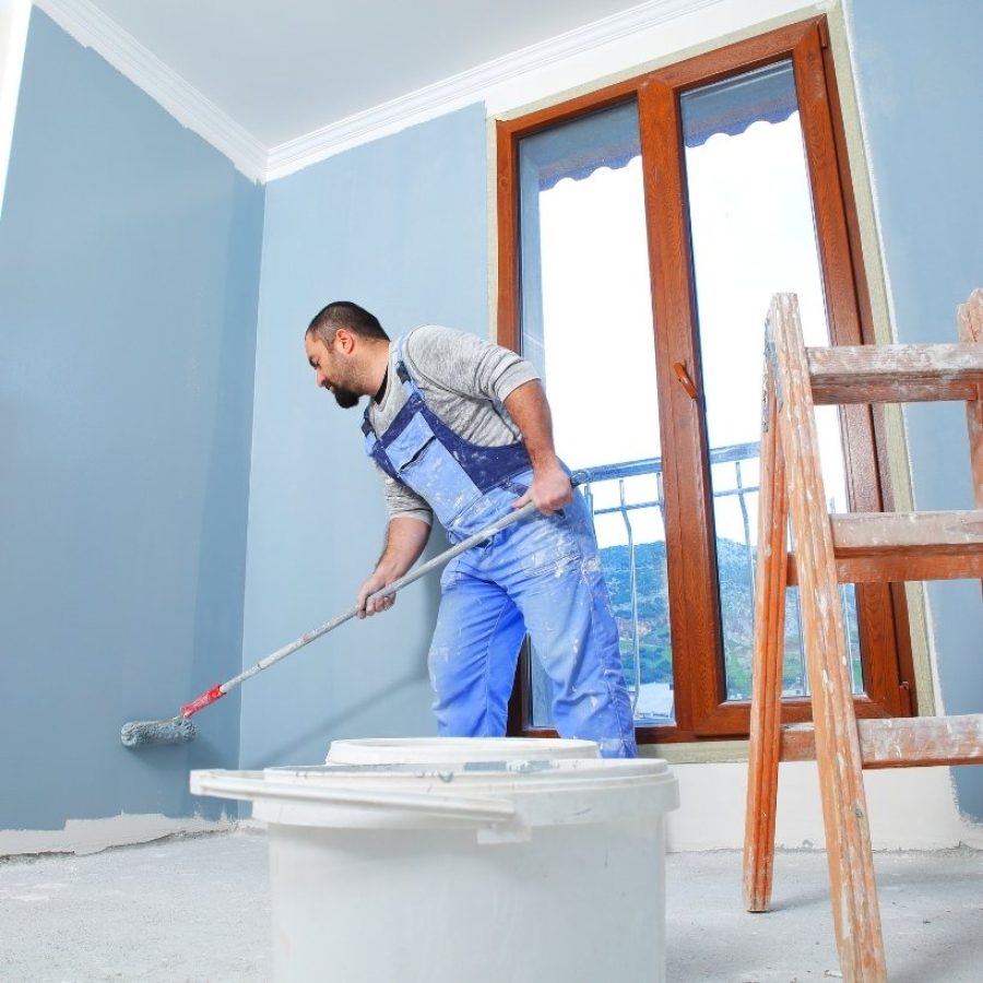 Trabajador pintando interior de vivienda como parte de remodelaciones rápidas de alto impacto en propiedades de inversión.