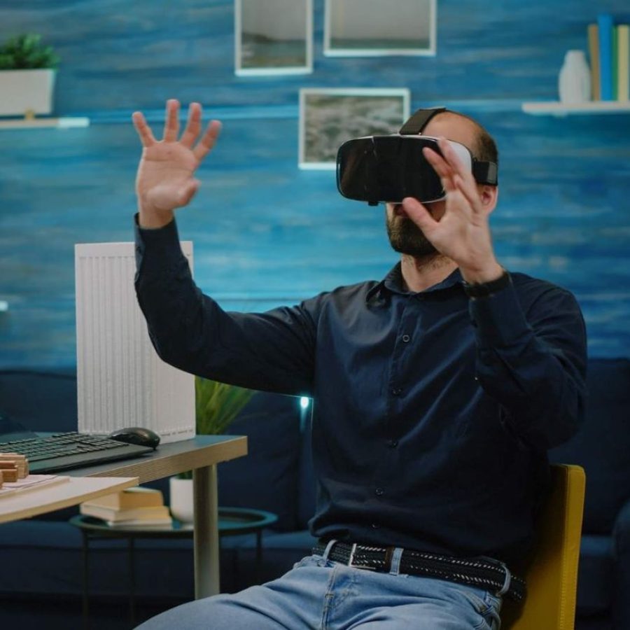 Hombre utilizando un visor de realidad virtual para explorar un modelo digital de una propiedad, demostrando el uso de tours 3D en el sector inmobiliario vacacional.