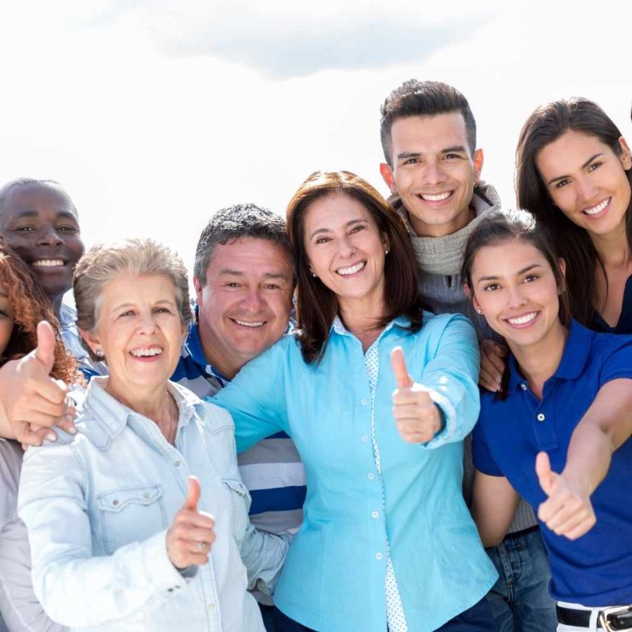 Un grupo de personas sonrientes levantando el pulgar en señal de aprobación.