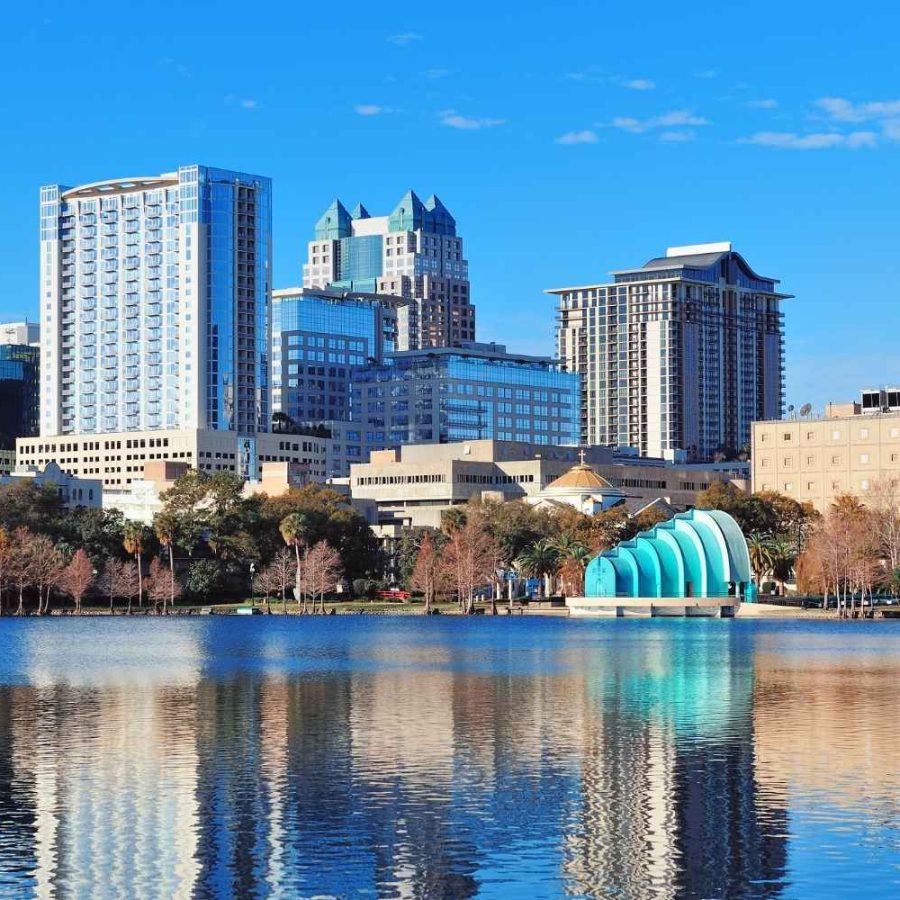 La silueta de la ciudad se ve reflejada en el agua, mostrando un contraste entre lo urbano y lo natural.